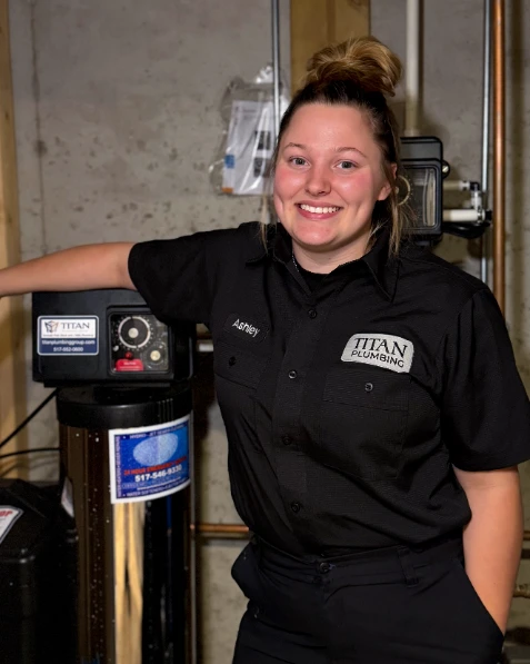 Titan technician Ashley, smiling in front of a fixed water softener